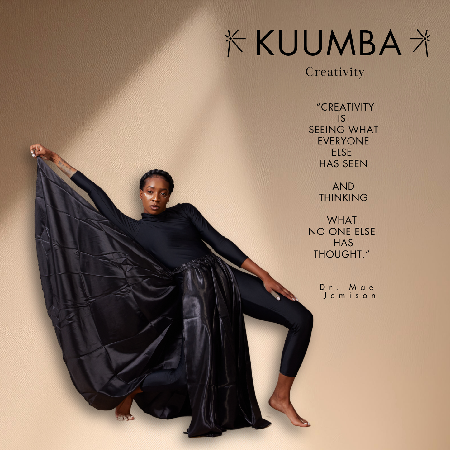 Person holding a black fabric with KUUMBA branding and a quote on creativity.